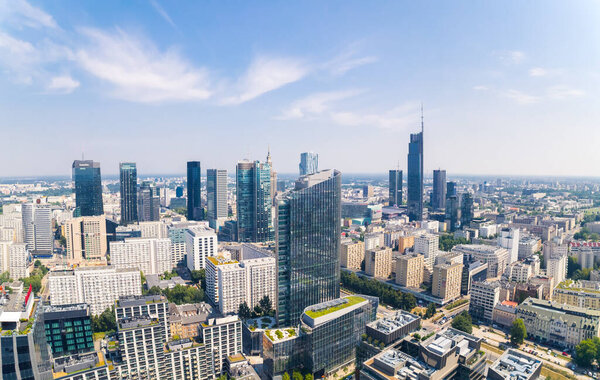 7.22.2022 Warsaw, Poland. Eclectic developing city. Neomodernism as a skyline architecture. Aerial drone shot, blue sky, sunny weather. High quality photo