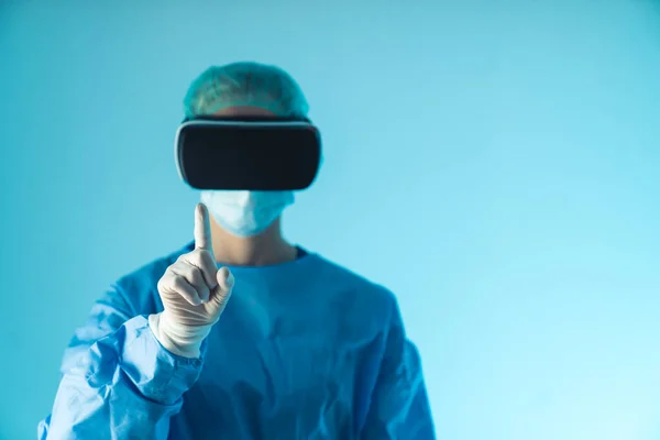 Surgeon doctor wearing virtual reality or augmented reality glasses to perform a futuristic surgery, holding up an index finger. High quality photo