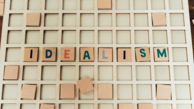 Protuberant white board with colourful letters creating a word IDEALISM. Advertisement concept. High quality photo