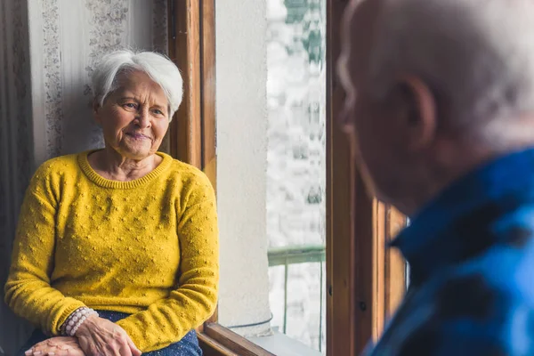 Caucasian Elderly Married Couple Home Sitting Frosty Window Talking Each — Stockfoto