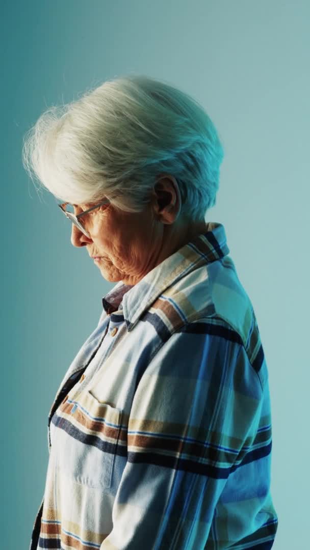 Vertical Shot Elderly Woman Sad Looking Light Source Blue Studio — Stock video