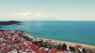 Aerial drone view of the famous village and long sandy beach of Sarti in South Sithonia, Halkidiki, Greece. Endless crystal clear sea. High quality 4k footage
