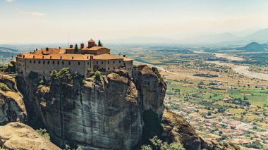 Drone shot of a famous place. Birds eye perspective of stunning Orthodox Meteora Monastery placed on the edge of high rock formation. Greek landscape. High quality photo