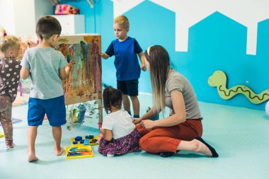 preschoolers painting on the special box in the kindergarten. High quality photo