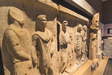07.13.2022 Thessaloniki, Greece. Well-preserved parts of white marble Greek statues carved in a wall. Greek characters. A visit to museum. High quality photo