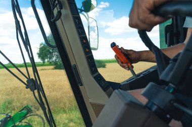 closeup view of farmers hands driving harvester. High quality photo