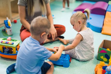 kids building objects with their lovely teacher at the nursery. High quality photo