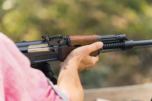 Hands holding rifle. Target practice. Gun training at firing range. Close-up outdoor horizontal shot. High quality photo