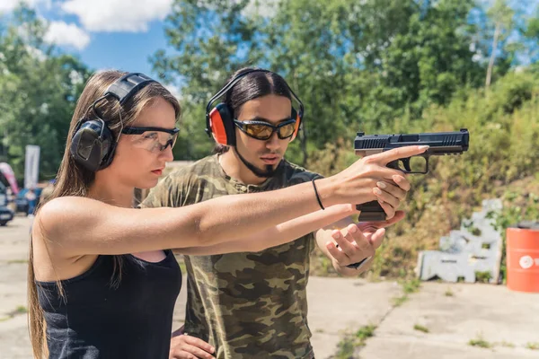 Male Instructor Showing Female Client How Aim Handgun Safety Goggles — Fotografia de Stock