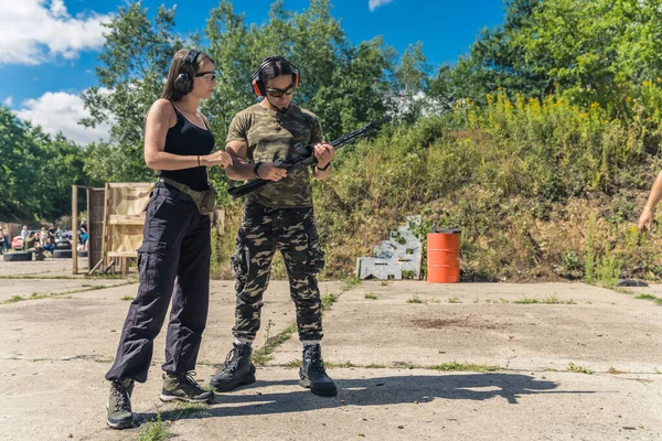 White Woman Instructing White Man How Use Submachine Gun Firearms — Zdjęcie stockowe