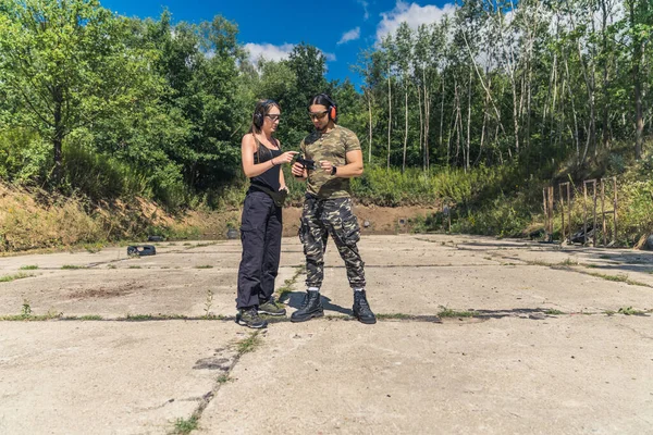 Woman Black Clothes Showing Man Camo Clothes How Operate Handgun — Stock Photo, Image