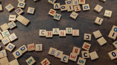 CHANGE. The need for a change represented symbolically with the use of little wooden square blocks with letters on them. High quality 4k footage
