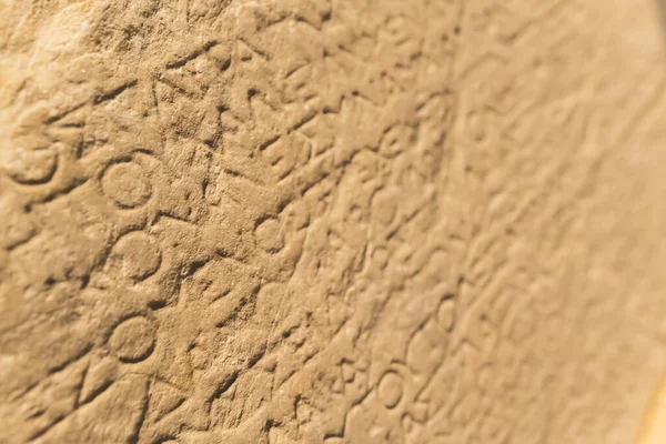 Greek language concept. Closeup shot of Greek alphabet words carved into a beige stone wall. High quality photo