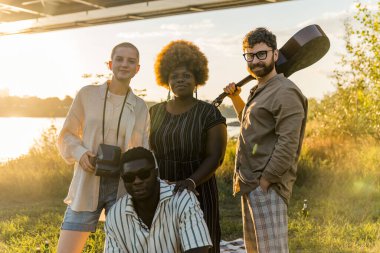 Multi-ethnic group of best old friends, who finally reunited after a long time separate living and studying in different countries. Creating memories in the blazing evening summer sun. . High quality