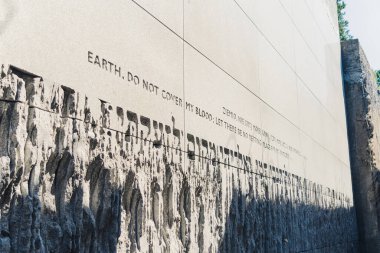 08.27.2022 - Belzec, Poland - Belzec Nazi Death Camp. Concrete wall with Polish and English writing at former nazi death camp ground. Holocaust memorial. Horizontal shot. High quality photo