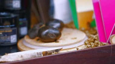 Alternative medicine for stressed and anxious people concept. Closeup shot of shiny oval CBD hashish balls places on a wooden table next to Palo Santo. . High quality 4k footage