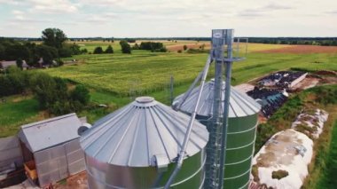 Aerial drone perspective of special high metal containers for wheat, rapeseed or other collected crops. Sunny weather. Protection. High quality 4k footage