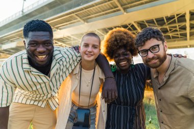 multiethnic friends taking a commemorative photo together, medium shot outdoors friendship concept. High quality photo