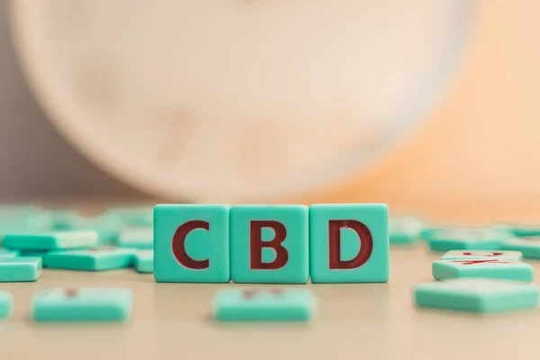The word CBD made of small colorful game board pieces with letters imprinted on them. Cannabis as herbal alternative medicine and chemical therapy. High quality photo
