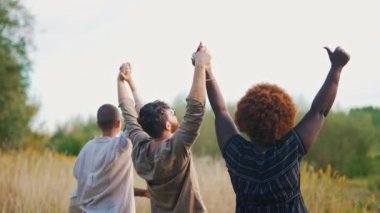 medium-full shot of multiethnic friends with their hands up. High quality 4k footage