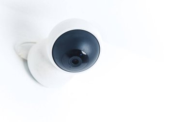 Isolated modern surveillance IP camera on a white wall. High quality photo