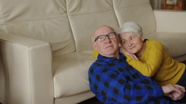 happy senior couple sitting on the floor and relaxing, medium shot. High quality 4k footage