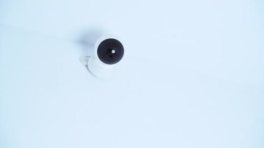 Isolated modern surveillance IP camera on a white wall. High quality 4k footage