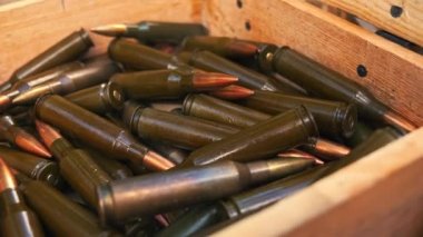 Close-up photo of rifle bullets stored in wooden box. Firearm ammunition. Military weaponry. Horizontal shot. High quality 4k footage