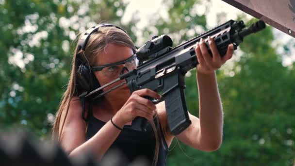 Young Caucasian Woman Wearing Protective Goggles Headphones Practising Submachine Gun — 图库视频影像