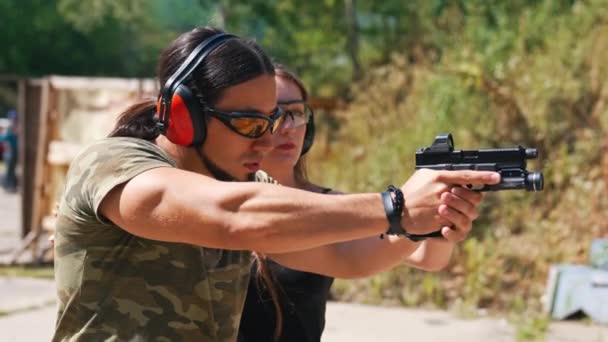 White Man Camo Shirt Safety Headphones Goggles Holding Handgun Female — Stock video