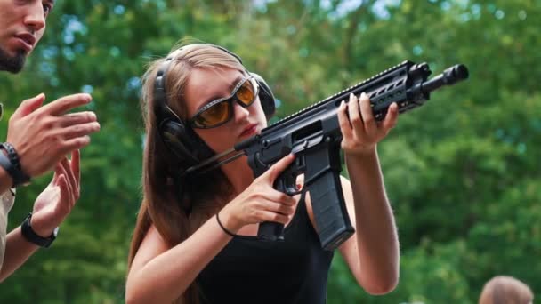 Caucasian Woman Wearing Safety Gear Aiming Submachine Gun Observed Male — Video Stock