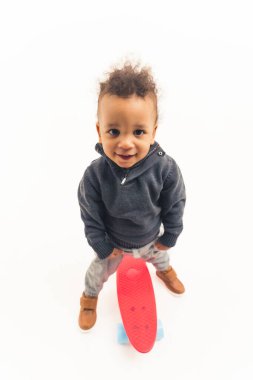 full shot of an Afro-American boy with a skateboard, studio shot vertical isolated. High quality photo