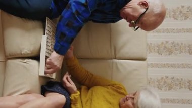 Caucasian senior couple enjoying at home, vertical video. High quality 4k footage