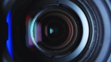 Close-up black professional camera lens zooming with hood and color reflections. High quality 4k footage