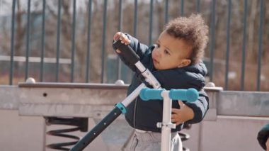 Afro-American little boy playing at the playground, medium shot. High quality 4k footage