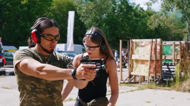 White Man Camo Shirt Safety Headphones Goggles Holding Handgun Female – Stock-video