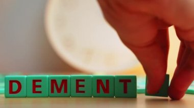 The word DEMENTIA made of small colorful cubes and many scrambled letters on the table. The loss of cognitive functioning thinking, remembering, and reasoning . High quality 4k footage