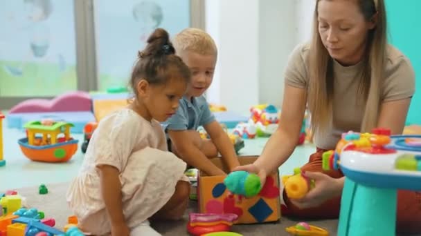 Kindergarten Kleinkinder Und Ihre Lehrerin Spielen Mit Bunten Plastik Spielhäusern — Stockvideo