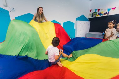 Anaokulunda dokuları ve renkleri ile aktif bir duyusal oyun oynayan mutlu çocuklar. Çocukların sağlığı için. Erken gelişmiş motor ve brüt motor becerileri. Yüksek kalite fotoğraf