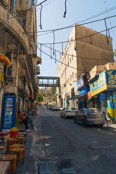 06.18.2022. Amman, Jordan. Amman 'da küçük pazarları, insanları ve arabaları olan dar bir sokak. Yüksek kalite fotoğraf