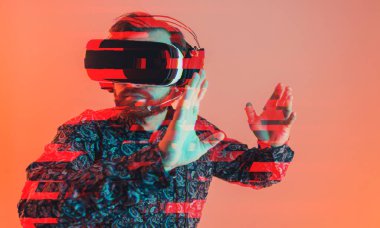 Kafkas sakallı, desenli tişörtlü adamda ellerini havaya kaldırırken VR kulaklık kullanmasında arıza var. Turuncu arka plan. Yüksek kalite fotoğraf