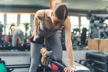 Genç atletik ve çekici kız spor salonunda ağırlık çalışıyor. Yüksek kalite fotoğraf
