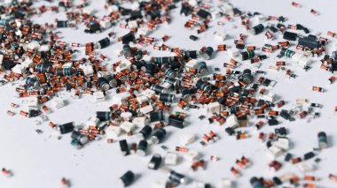 Beyaz yüzeyinde turuncu ve mavi elementler olan renkli, küçük silindirik elektronik parçalar. Hassas teknoloji. Devre kartı parçaları. Yatay çekim. Yüksek kalite fotoğraf