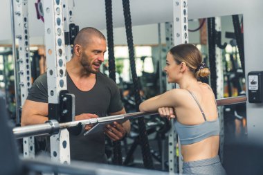 Genç bir kadın spor salonunda eğitmeniyle konuşuyor, orta boy fitness yaşam tarzı. Yüksek kalite fotoğraf