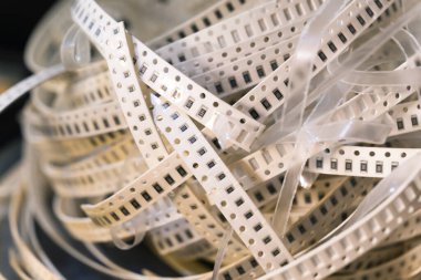 SMD elektrik devresi bileşenleriyle karışık beyaz bant paketi monte edilecek. Yüzey yükseliyor. Yedek parça. Modern teknoloji. Yatay yakın plan çekim. Yüksek kalite fotoğraf