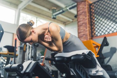 Spor salonundaki makinede çalışan genç bir kadın, fitness ve aktif yaşam tarzı. Yüksek kalite fotoğraf