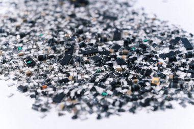 Devre kartı için çeşitli elektrik bileşenleri karıştırılmış ve beyaz yüzeye saçılmış. Gümüş ve siyah. Teknoloji. Yatay çekim. Yüksek kalite fotoğraf