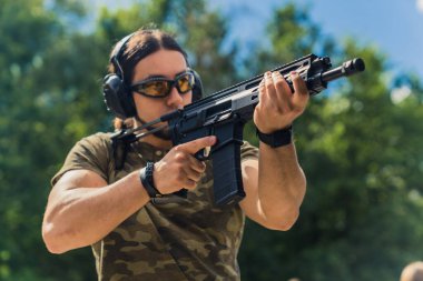 Orta yaşlı Avrupalı bir adam atış poligonunda antrenman yapıyor. Yüksek kalite fotoğraf