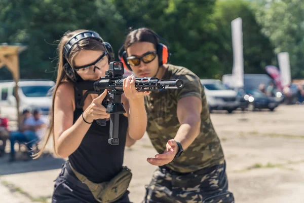 Muscular Male Instructor Helping Beautiful Caucasian Girl Handle Rifle Collimator — Stock Photo, Image