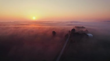 Roztocze Polonya 'da sabah sisi olan yeşil ve kahverengi tarım tarlalarının üzerinde canlı turuncu gün doğumunun kuşbakışı görüntüsü. Geniş yatay çekim. Yüksek kalite 4k görüntü